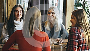 Four female friends enjoying in talking at cafe