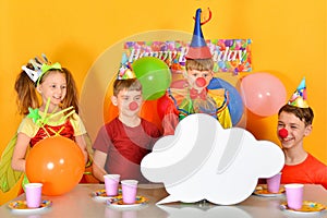 Four festively dressed children are looking at an empty cloud