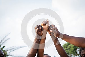 Four fists of African people united in sky, photo with copy space