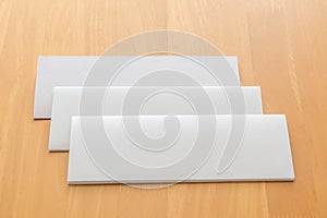 Four fold white template paper on wood background.