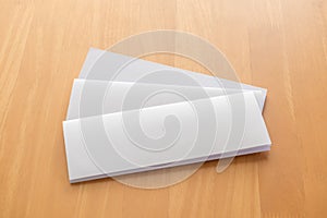 Four fold white template paper on wood background.