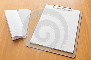 Four fold white template paper with wooden clipboard on wood background