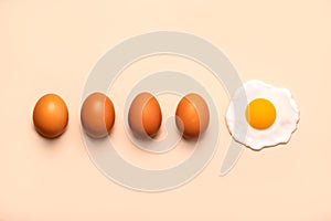 Four fresh brown eggs next to a fried egg