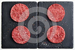 Four fresh raw Prime Black Angus beef burger patties