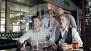 Four friends businessmen drink beer and rejoice