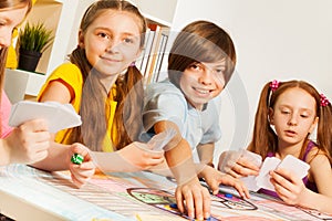 Four friends playing cards sitting at gaming table