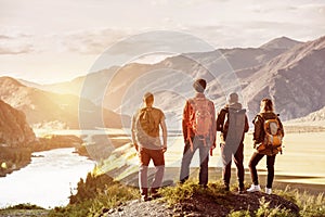 Four friends sunset mountains travel concept