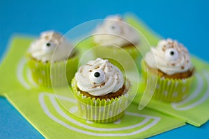 Four funny cream cupcakes with two little eyes