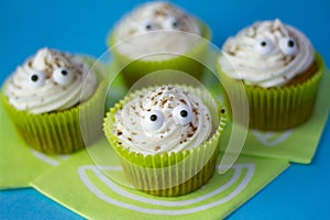 Four funny cream cupcakes with two little eyes