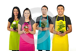 Four gardeners workers offering flowers