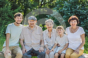 Four generations of family spend time together in the park. Elderly couple. Senior husband and wife holding hands and