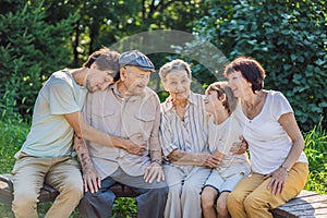 Four generations of family spend time together in the park. Elderly couple. Senior husband and wife holding hands and