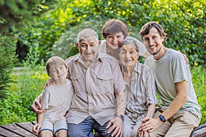 Four generations of family spend time together in the park. Elderly couple. Senior husband and wife holding hands and