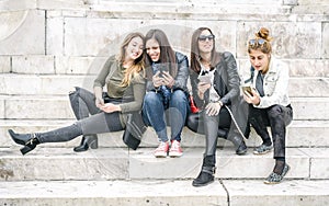 Four girl friends happy watching internet social media in smartphone