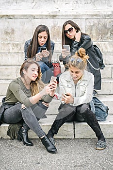 Four girl friends happy watching internet social media in smartphone