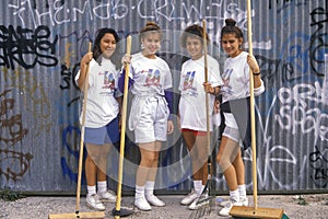 Four girls participating in community cleanup