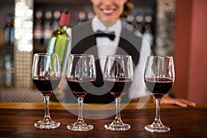 Four glasses of red wine ready to serve on bar counter