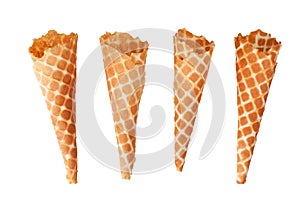 Four golden crispy ice cream waffle cones on white background isolated closeup top view