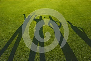 Four golfers silhouette on grass