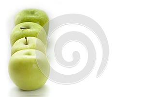 Four Green apples lie in a row on the side on a white background. selectiv focus. flat lay