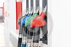 Four handles of fuel hoses on gas station ready for refueling cars