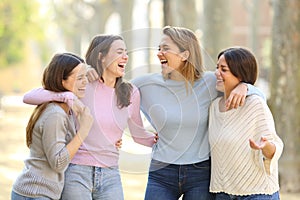 Four happy friends laughing in the street