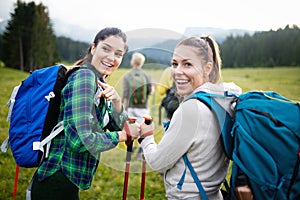 Four happy friends are looking on mountains and having fun together