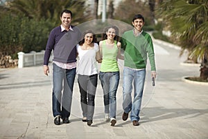 Four happy people walking