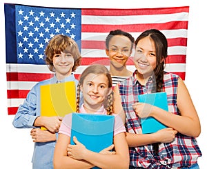 Four happy students standing against American flag