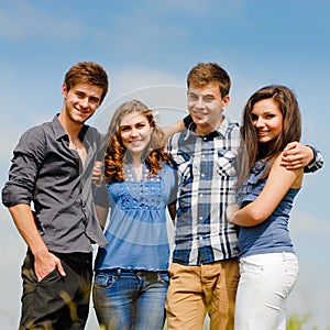 Four happy teenage friends outdoors