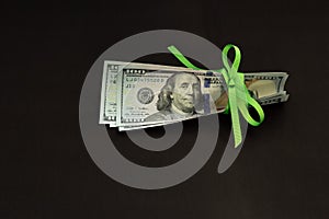 Four hundred us dollars on a black background tied with a green ribbon