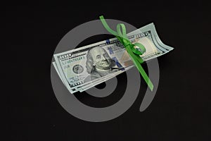 Four hundred us dollars on a black background tied with a green ribbon