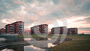 Four identical apartment buildings close to a lake and a park during summer sunset in Lund Sweden