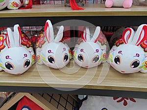 Four identical similar white auspicious rabbit soft toys on display