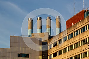 four industrial chimneys on top of a modern building