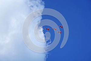 Four jet fighters, military planes flying into a white cloud against a blue sky, aerobatics