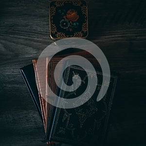 Four Journals and a Colorful Canister on a Wooden Textured Background