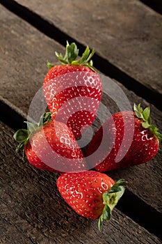 Four juicy strawberry on wooden plank