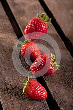 Four juicy strawberry on wooden plank