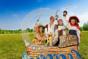 Four kids in pirate costumes behind ship