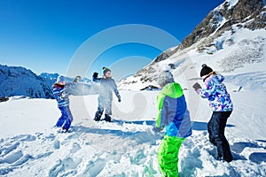 Four kids play active winter snowball fun game