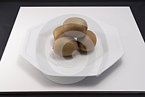 Four kiwis on white plate