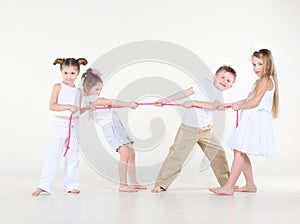 Four little children in white pull pink rope.