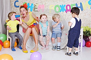 Four little kids with juice and entertainer sit on photo