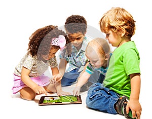 Four little kids playing tablet