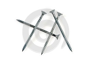 Four long self tapping iron screws with flat head, macro close-up isolated on white background.