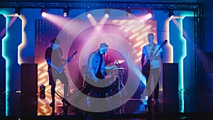 Four Man Rock Band with Lead Singer, Guitarists, Bassist and Drummer Performing at a Concert in a
