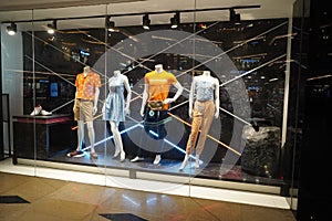 Four Mannequins Dressed In Male and Female Casual Clothes In Boutique Store Of Shopping Center. View of a Fashion shop front. -