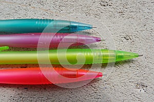 Four mechanical pencils, colored green, pink, blue and purple