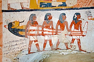 Four men carrying a mummy